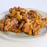 Cinnamon maple glazed walnuts on a small plate