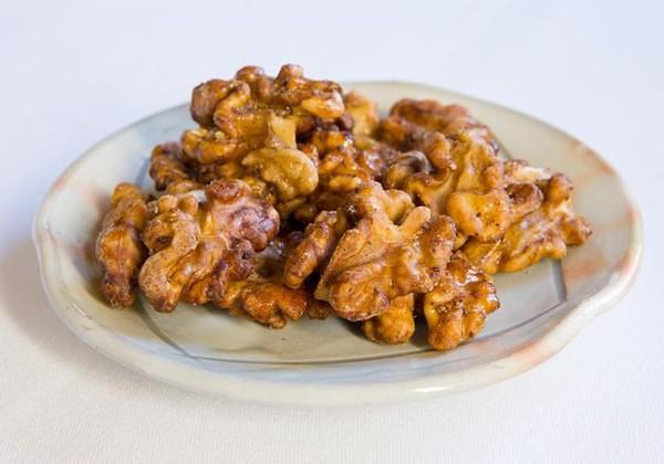 Cinnamon maple glazed walnuts on a small plate